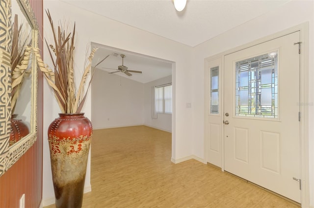 foyer entrance featuring a textured ceiling, light wood-type flooring, and ceiling fan