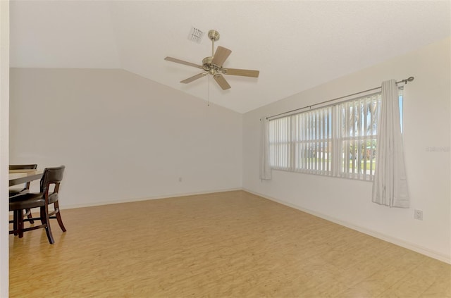 spare room featuring light hardwood / wood-style floors, lofted ceiling, and ceiling fan