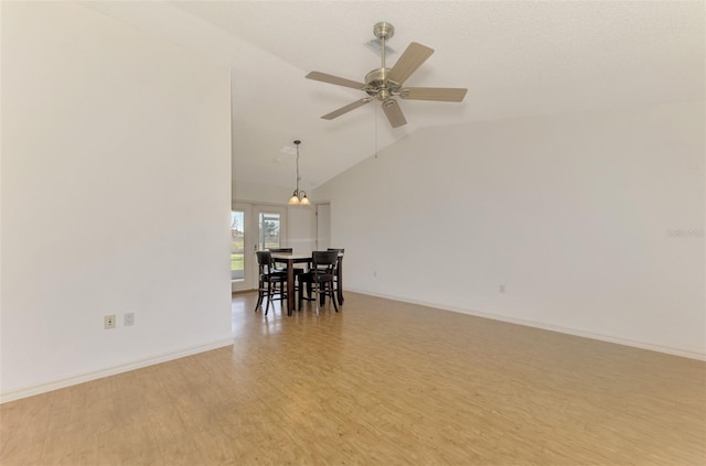 unfurnished dining area featuring lofted ceiling, wood-type flooring, and ceiling fan