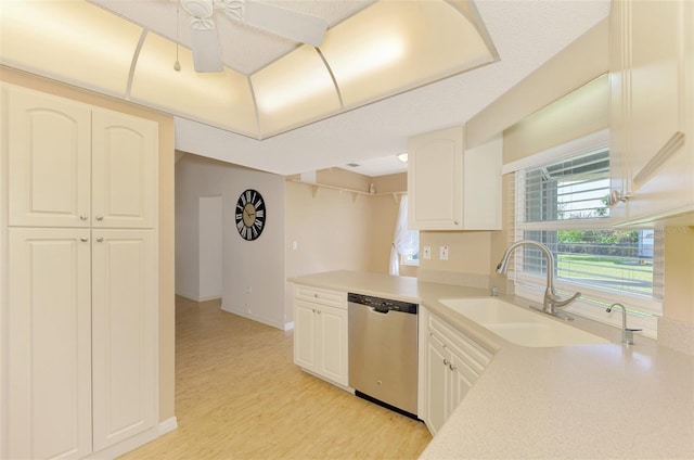 kitchen featuring white cabinetry, stainless steel dishwasher, sink, and light wood-type flooring