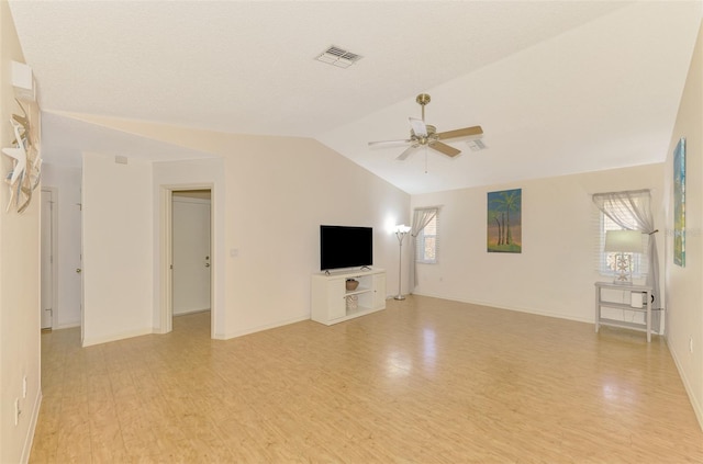 unfurnished living room featuring light hardwood / wood-style flooring, vaulted ceiling, a wealth of natural light, and ceiling fan