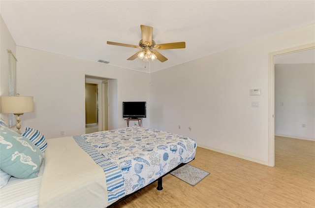 bedroom featuring a textured ceiling, wood-type flooring, and ceiling fan