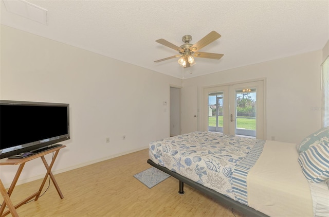 bedroom featuring a textured ceiling, wood-type flooring, access to outside, and ceiling fan