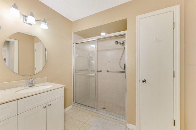 bathroom featuring vanity, a shower with shower door, and tile patterned floors