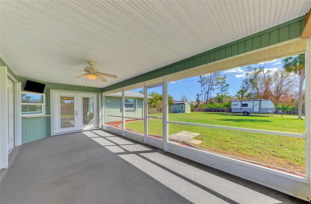 unfurnished sunroom featuring ceiling fan