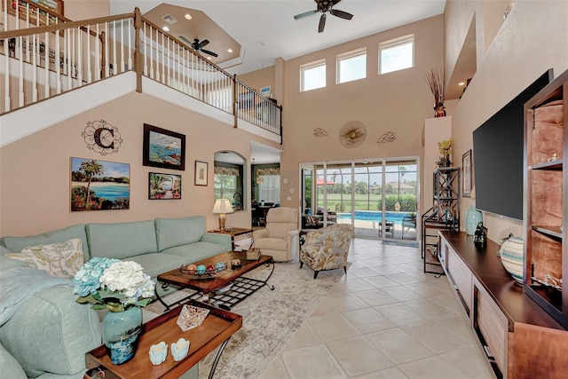 living room with light tile patterned flooring, a high ceiling, and ceiling fan