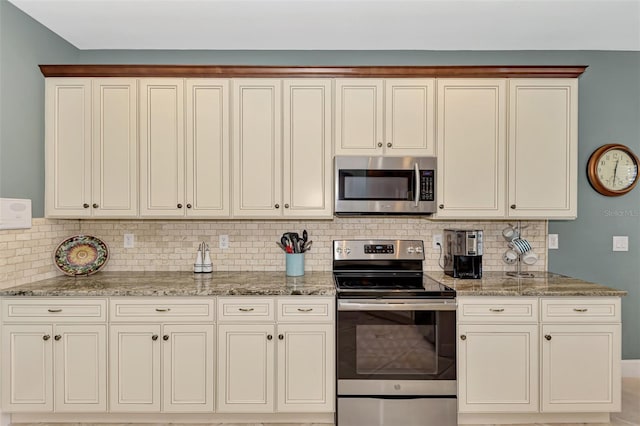 kitchen with decorative backsplash, appliances with stainless steel finishes, and light stone counters