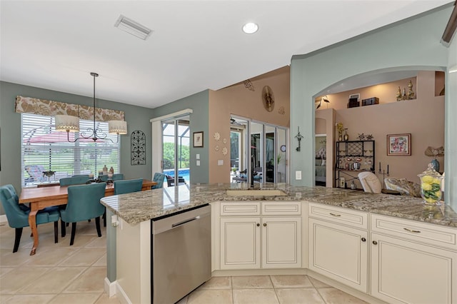 kitchen with light tile patterned floors, light stone countertops, dishwasher, and an inviting chandelier