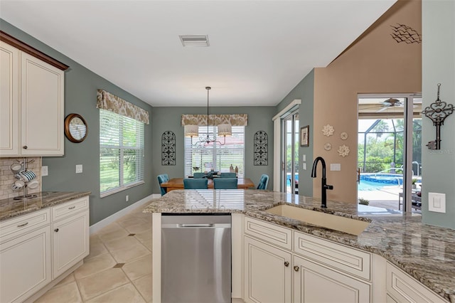 kitchen with light tile patterned flooring, sink, backsplash, pendant lighting, and stainless steel dishwasher