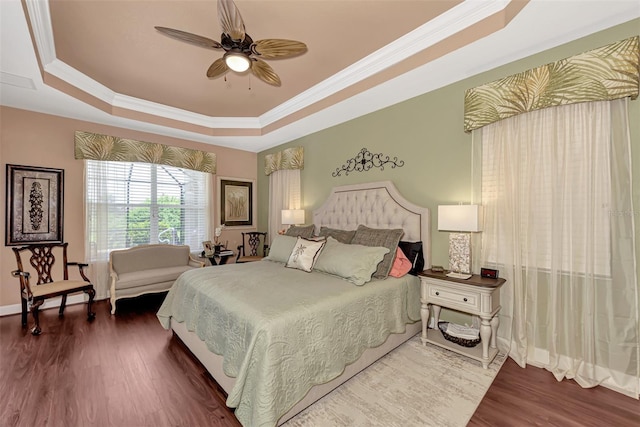 bedroom featuring dark hardwood / wood-style floors, a raised ceiling, and ceiling fan