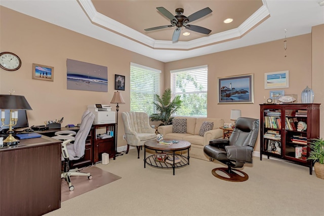 carpeted office space with crown molding, a tray ceiling, and ceiling fan