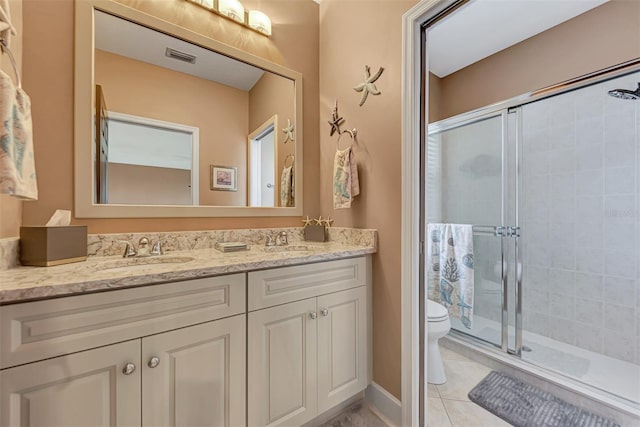 bathroom with vanity, tile patterned flooring, toilet, and walk in shower