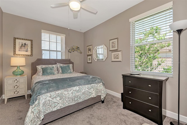 carpeted bedroom with ceiling fan and multiple windows