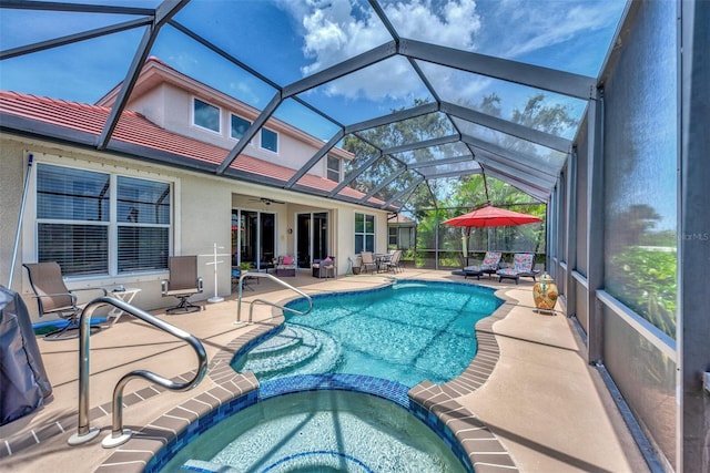 view of pool with an in ground hot tub, ceiling fan, a patio, and a lanai