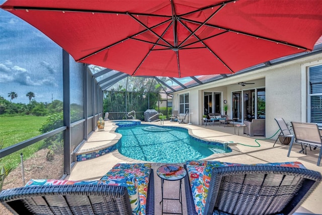 view of swimming pool with a patio, a lanai, and ceiling fan