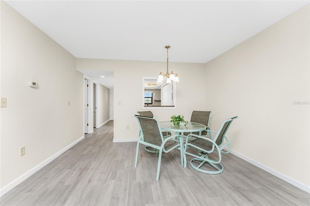 dining space with a notable chandelier and light wood-type flooring