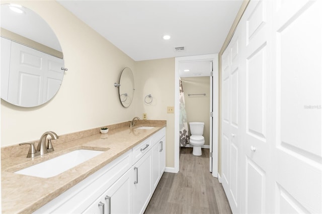 bathroom with toilet, hardwood / wood-style flooring, and vanity