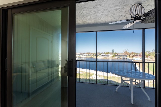 balcony with a water view and ceiling fan