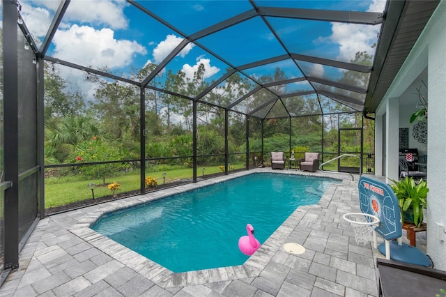 view of pool with a patio area and glass enclosure