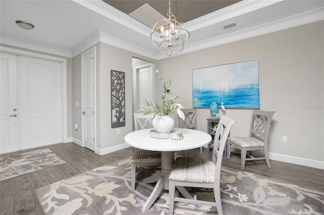 dining area featuring an inviting chandelier, ornamental molding, and hardwood / wood-style floors