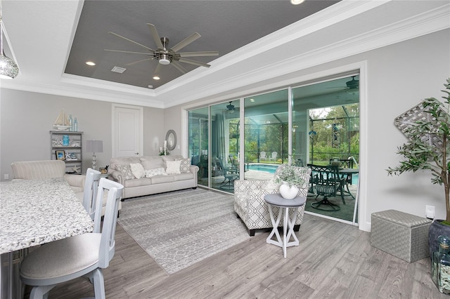 bedroom with wood-type flooring, access to outside, a tray ceiling, ceiling fan, and ornamental molding