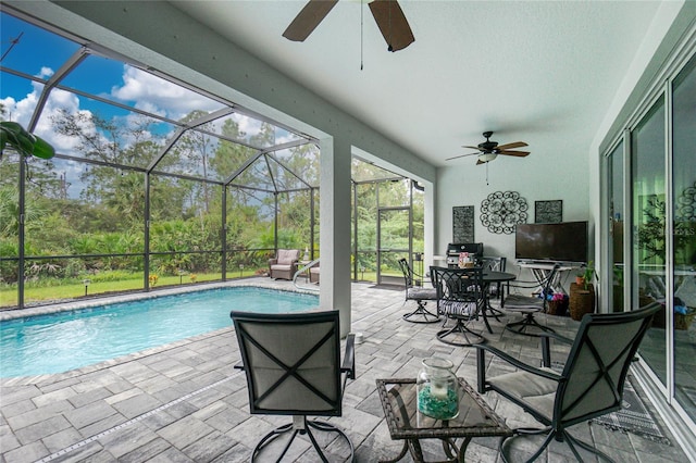 view of pool with a patio area, glass enclosure, and ceiling fan