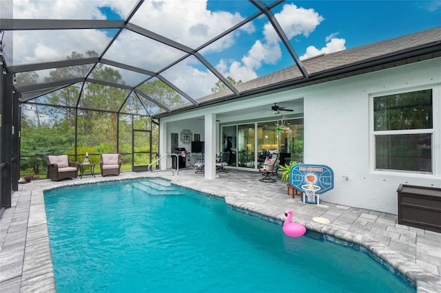 view of swimming pool with a patio, a lanai, and ceiling fan