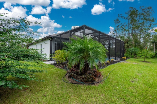 view of side of home with glass enclosure and a lawn