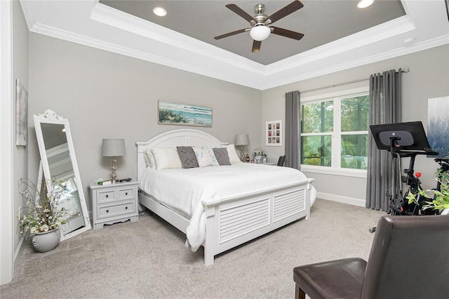 carpeted bedroom featuring ceiling fan, crown molding, and a tray ceiling