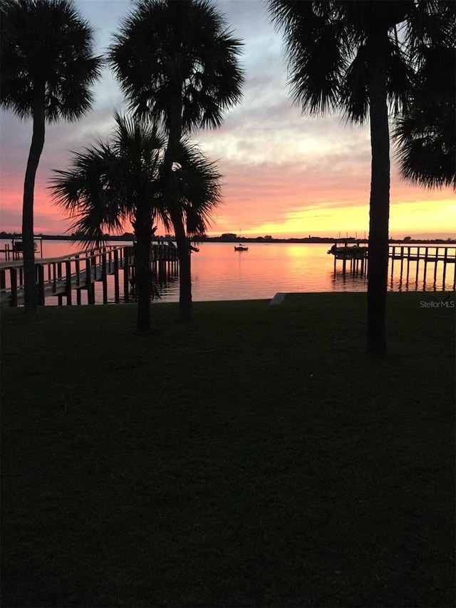 yard at dusk featuring a water view