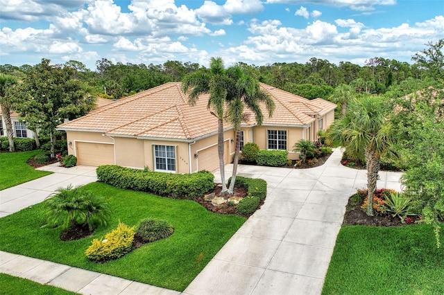mediterranean / spanish-style house with stucco siding, driveway, and a front yard