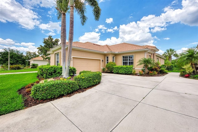 mediterranean / spanish house with concrete driveway, a garage, a tile roof, and stucco siding