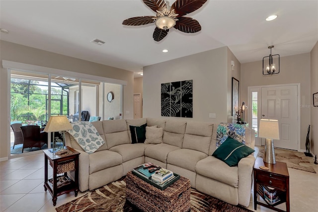 living room featuring visible vents, light tile patterned floors, baseboards, ceiling fan with notable chandelier, and recessed lighting