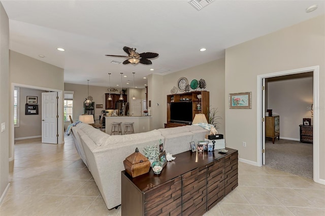 living area with visible vents, a ceiling fan, baseboards, and light tile patterned floors