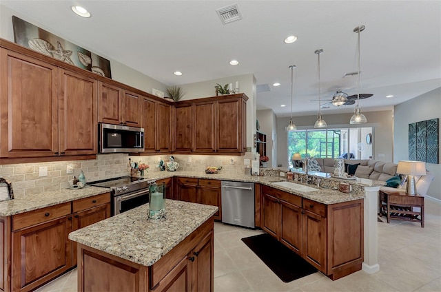 kitchen featuring backsplash, appliances with stainless steel finishes, a sink, light tile patterned floors, and a peninsula