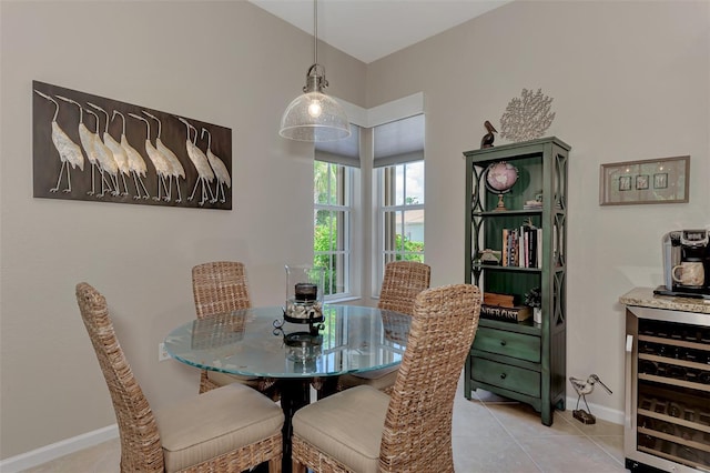 dining area with light tile patterned flooring, baseboards, and wine cooler