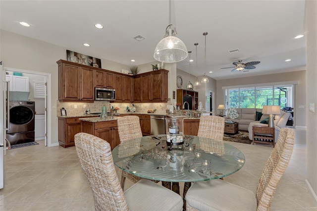 tiled dining space with washer / dryer, ceiling fan, and sink