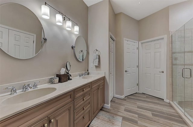 bathroom with a shower with door, vanity, and wood-type flooring