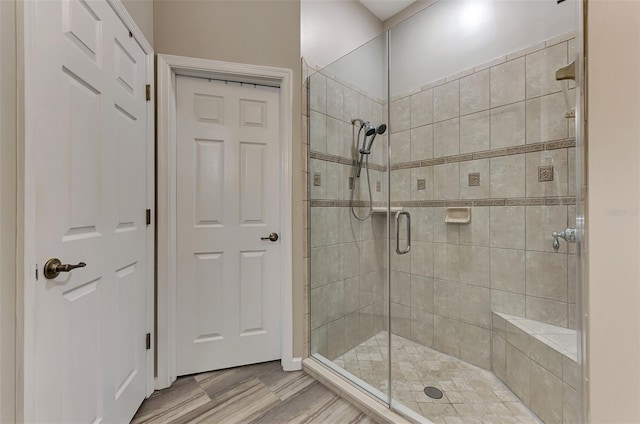 bathroom with an enclosed shower and wood-type flooring