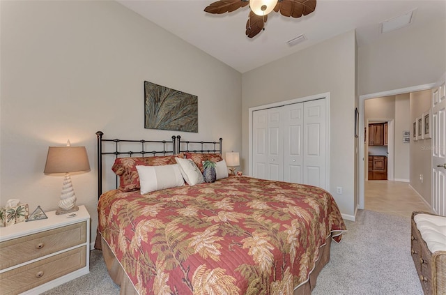 bedroom with a closet, light colored carpet, lofted ceiling, and ceiling fan