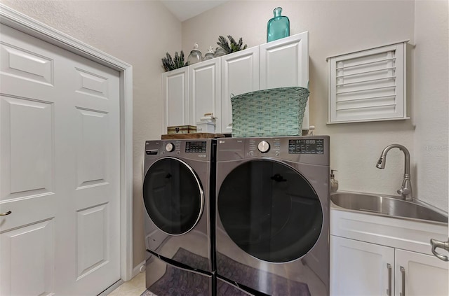 washroom featuring cabinets, sink, washing machine and clothes dryer, and light tile patterned floors