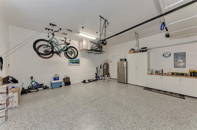 garage with a garage door opener, stainless steel refrigerator, electric panel, and water heater