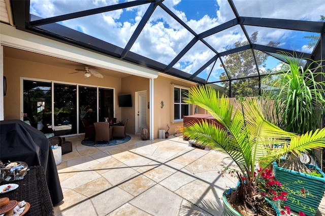 view of patio / terrace featuring ceiling fan and glass enclosure