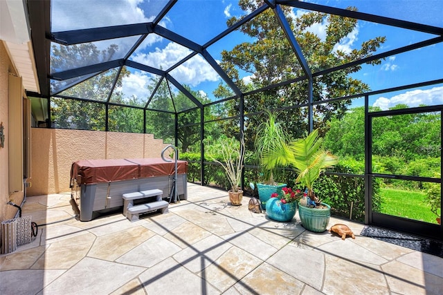 view of patio / terrace with a lanai and a hot tub