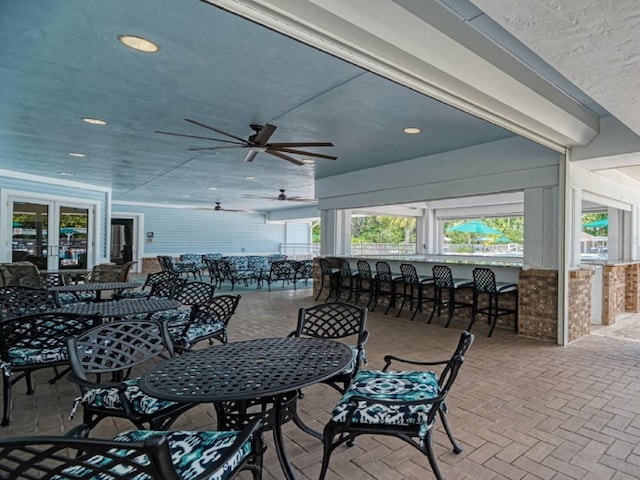 view of patio / terrace featuring an outdoor bar, a ceiling fan, and outdoor dining area