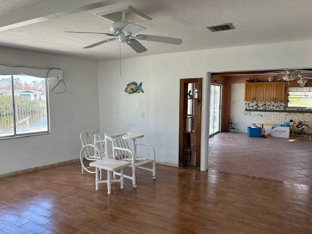 dining room featuring ceiling fan, dark wood-type flooring, and a textured ceiling