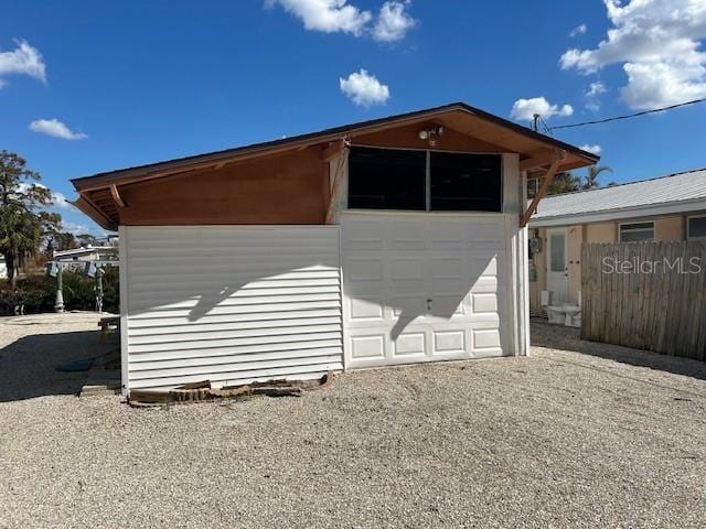 exterior space featuring a garage and an outbuilding