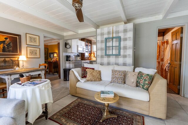 tiled living room featuring beamed ceiling and ceiling fan