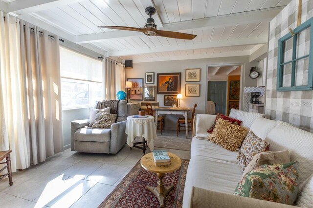 living room featuring beam ceiling, light tile patterned floors, wood ceiling, and ceiling fan