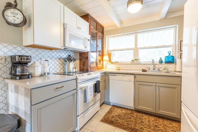 kitchen with white appliances, beam ceiling, backsplash, and gray cabinets